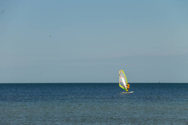 istock Windsurfing. Surfer exercising in calm sea or ocean. 857432944