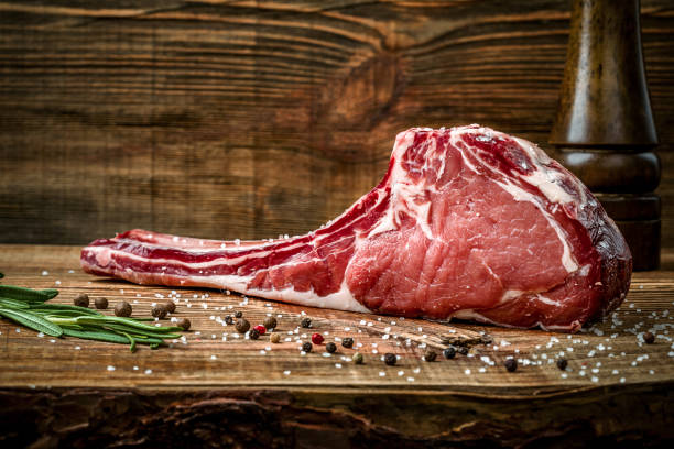 dry aged raw tomahawk beef steak with ingredients for grilling - carne talho imagens e fotografias de stock