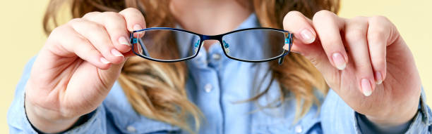 istock Young woman holding reading glasses, ophthalmology banner 857436730