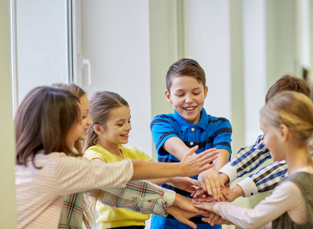 istock group of smiling school kids putting hands on top 857444902