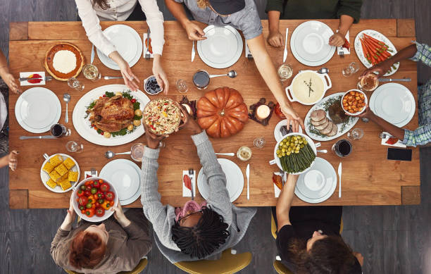 It’s a time for giving and sharing Shot of a group of people sitting together at a dining table ready to eat serving size stock pictures, royalty-free photos & images