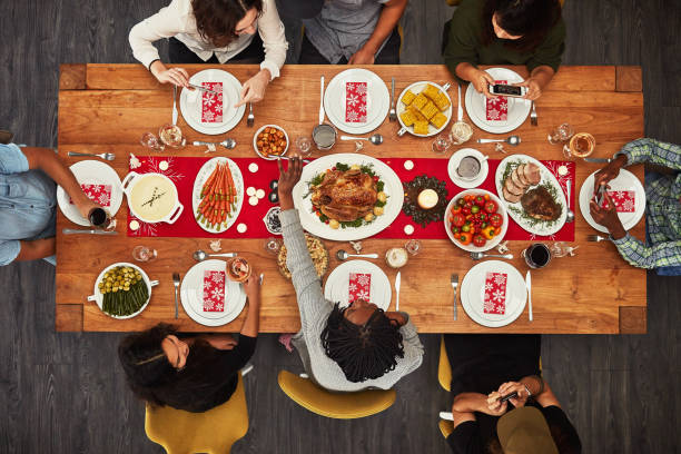 It wouldn’t be a gathering without food Shot of a group of people sitting together at a dining table ready to eat roast beef photos stock pictures, royalty-free photos & images