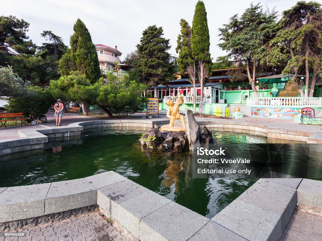 ountain Boy with Fish in Alushta in morning Alushta: tourist near fountain Boy with Fish on Lenin Street Embankment in Alushta in morning. Alushta is seaside resort town on southern coast of the Crimean peninsula. Alushta Stock Photo