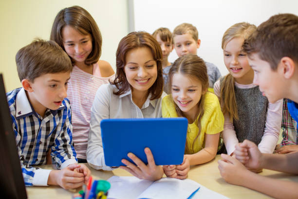 istock group of kids with teacher and tablet pc at school 857446422