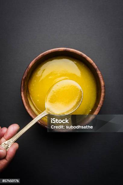 Ghee Or Clarified Butter Close Up In Wooden Bowl And Silver Spoon Selective Focus Stock Photo - Download Image Now