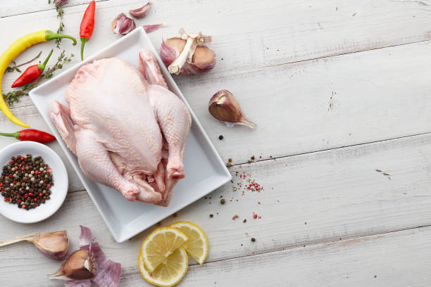 istock Raw chicken, herbs and spices on white wooden background 857464956