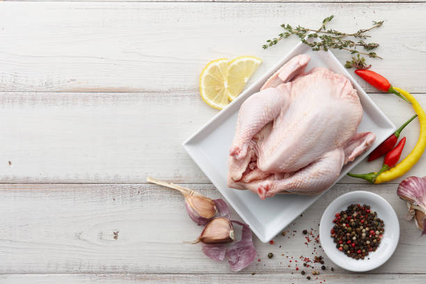 istock Raw chicken, herbs and spices on white wooden background 857472582