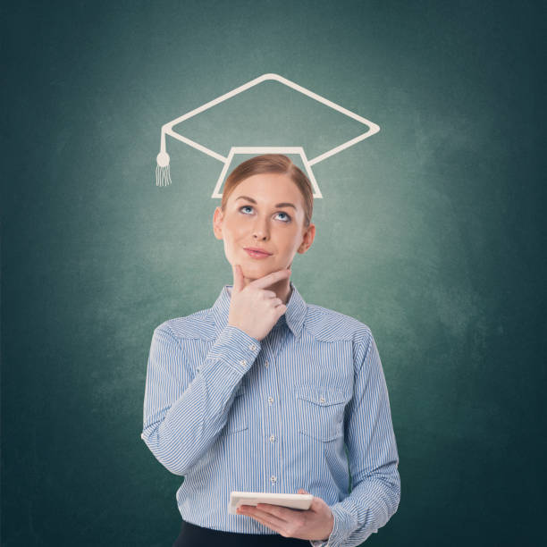 istock Female student holding digital tablet with mortarboard over her head 857474612