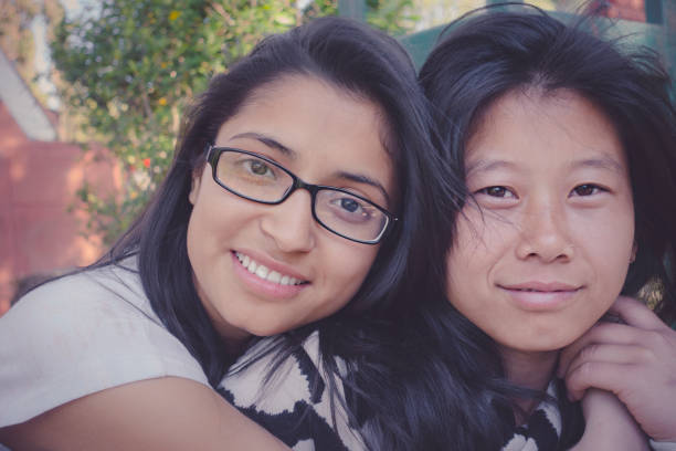istock Happy multi ethnic friends sitting together and looking at camera. 857478254