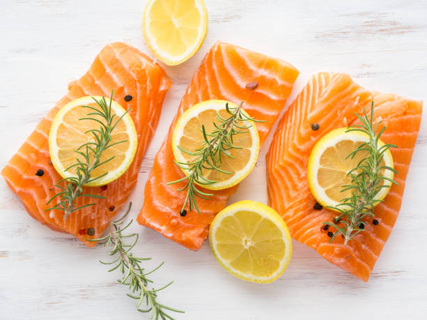 istock Raw salmon on wooden board with herbs 857489230