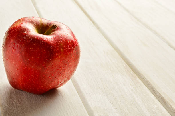 manzana sobre fondo de madera - drop red delicious apple apple fruit fotografías e imágenes de stock