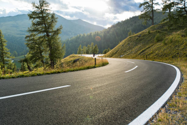 carretera asfaltada en austria, alpes, en un día de verano - carretera de campo fotografías e imágenes de stock