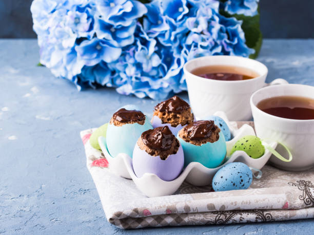 istock Easter sweet cup cakes treets in colorful egg shells on blue 857493022