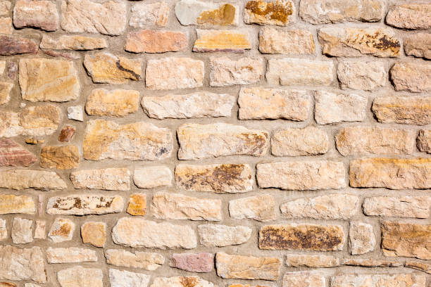 Old, classic, beige sandstone wall with rustic charm Old, classic, beige sandstone wall with rustic charm. sand stone wall stock pictures, royalty-free photos & images