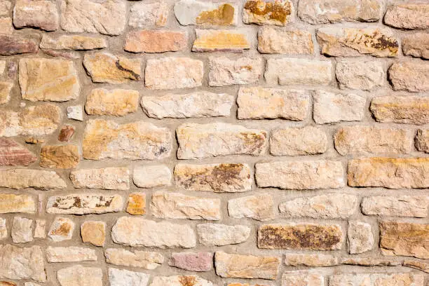 Old, classic, beige sandstone wall with rustic charm.