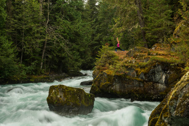 istock Woman practicing yoga alongside a raging river 857500456
