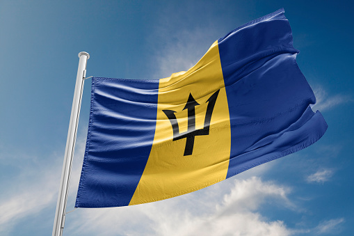 Barbados flag is waving at a beautiful and peaceful sky in day time while sun is shining. 3D Rendering