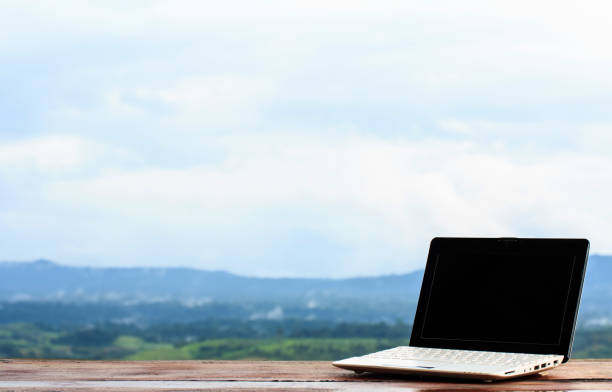 istock Laptop stands on a wooden table outdoors and nature background 857501508