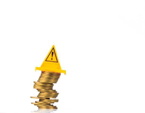 istock Financial risk. Coins falling and Warning label on whitebackground 857501510