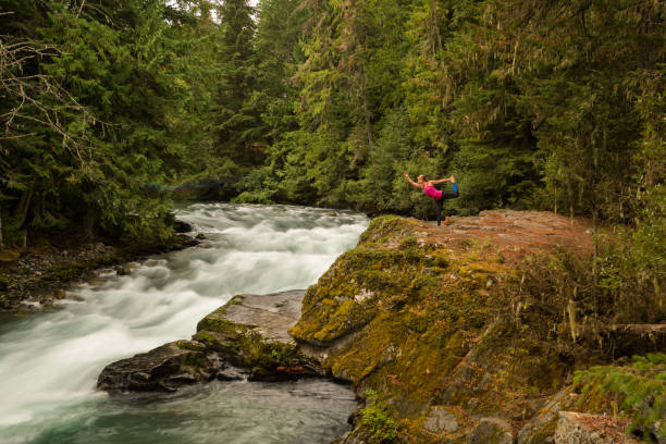 istock Woman practicing yoga alongside a raging river 857501602