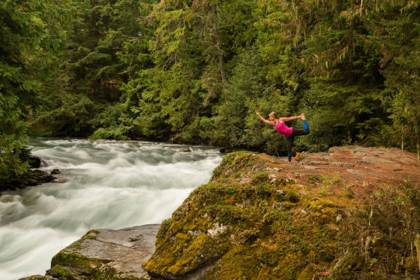 istock Woman practicing yoga alongside a raging river 857501768