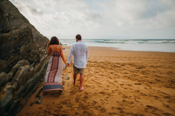 istock Young couple walking at the beach 857505146