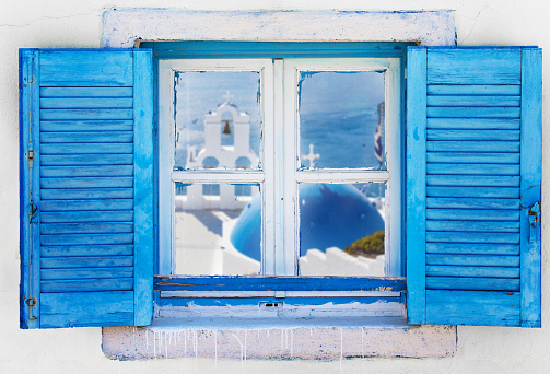 Beautiful vintage Greek window with blue shutters on a white wall. Typical Greek picture.