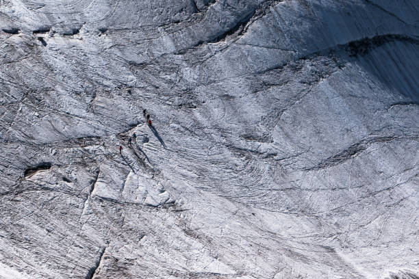 istock Walkers secured with ropes crossing alpine glacier in summer 857514178