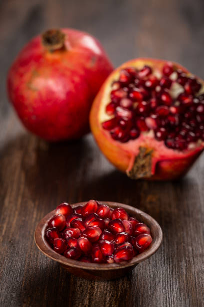istock Pomegranate fruit on wooden vintage background 857514854