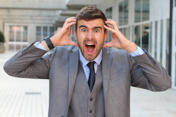istock Businessman showing hysteria close up with copyspace 857525874