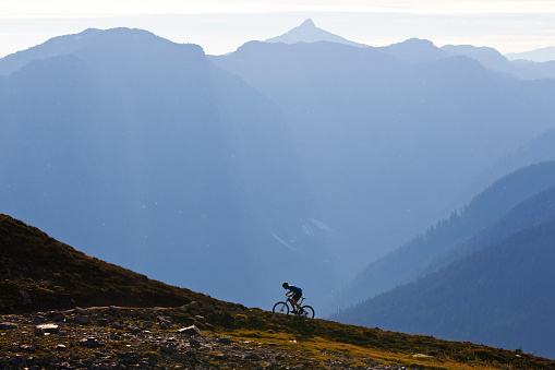 Un hombre monta a un sendero de bicicleta de montaña escarpada en la Columbia Británica, Canadá. photo