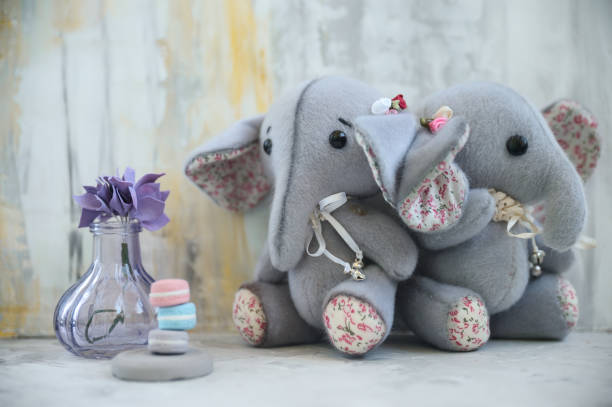 istock Handmade toy two gray elephants with purple flower 857530244