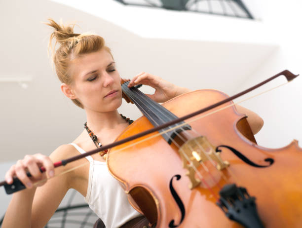 istock Young woman playing violoncello on the stage 857533114