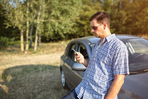 istock Road trip break after long drive- man using phone 857533988