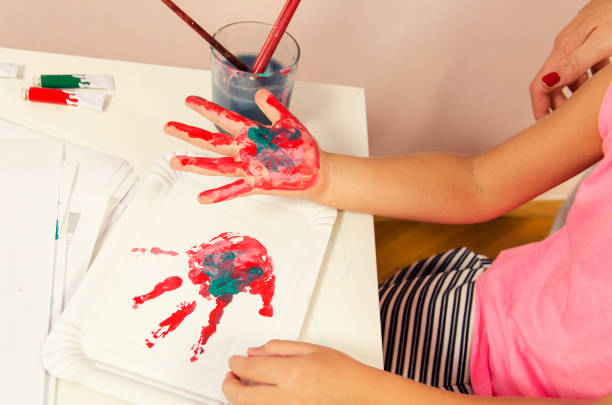 istock Cute girl leaving hand print on paper 857541376