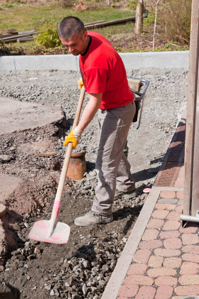 istock Road construction worker filling a pit with gravel 857552166