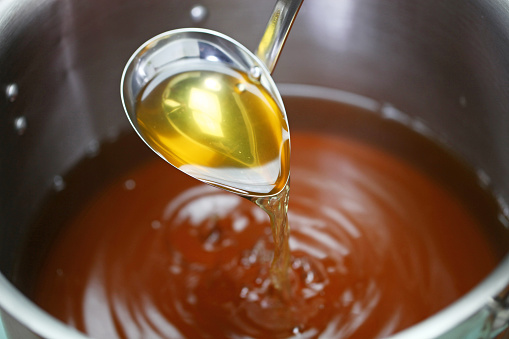 making chicken consomme soup in a pot