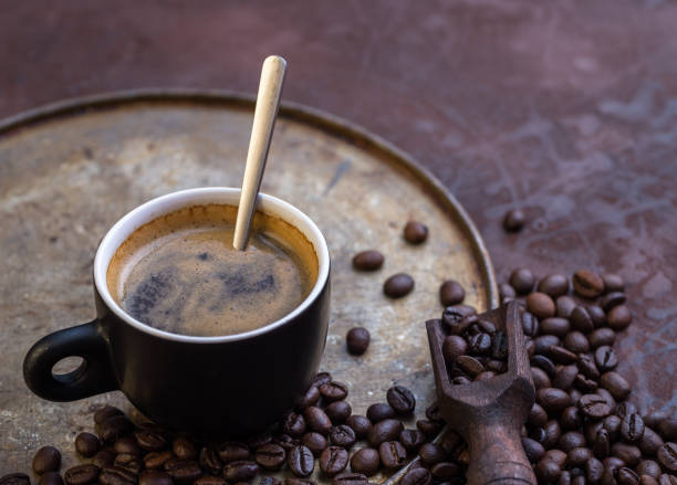 istock Cup of coffee on rustic background with coffee beans around. 857569154