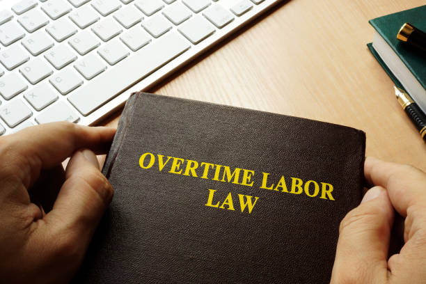 Book with title overtime labor law. Book with title overtime labor law. working late stock pictures, royalty-free photos & images