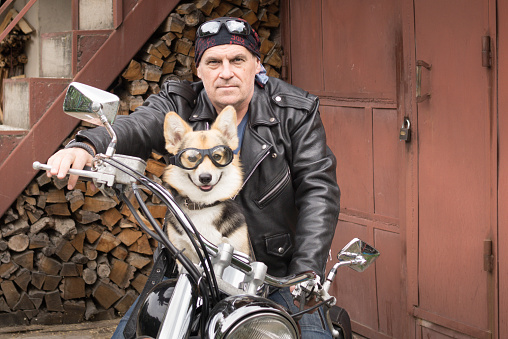 Photo of humor. The biker and his dog are sitting on a motorcycle.
