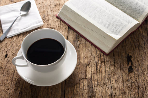 istock Coffee cup and open book on wooden table 857574602