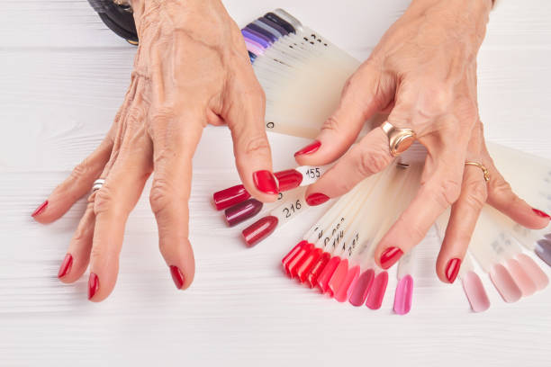 istock Old woman compares nail color with nail sample. 857581034