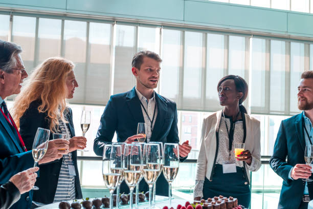Business event Colleagues standing and drinking champagne on business event community center food stock pictures, royalty-free photos & images