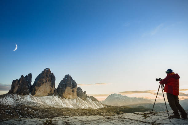 istock Man photographs the moon above mountains landscape 857586812