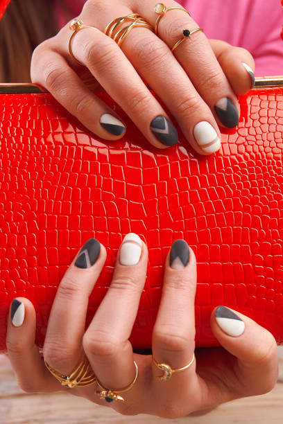 istock Well-groomed hands holding red handbag. 857588546
