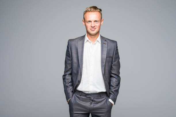 istock Happy smiling businessman hands in pocket with blank copyspace area for text or slogan, against grey background 857589138