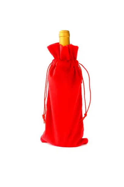 Wine bottle in handmade red velvet Christmas wine bottle bag on white background.