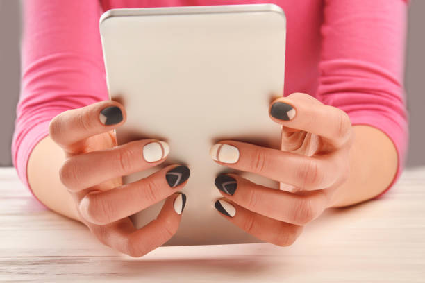 istock Manicured hands holding smartphone. 857589526