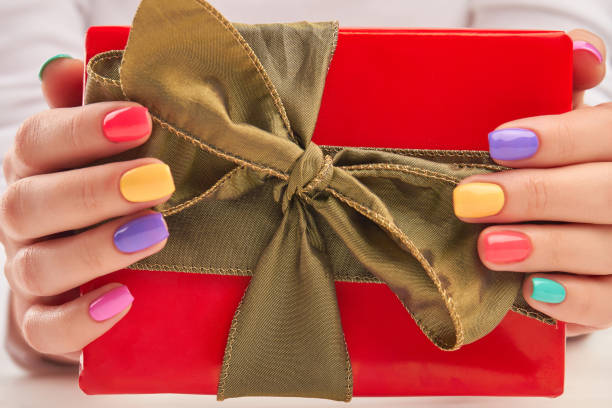istock Gift box in manicured female hands. 857591924