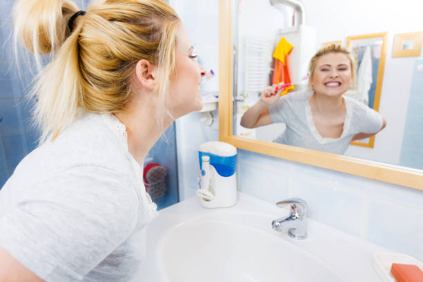 istock Woman brushing cleaning teeth in bathroom 857592002
